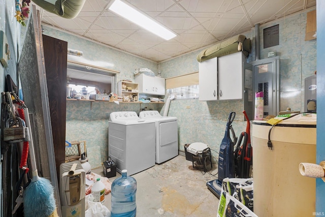 clothes washing area with washer and clothes dryer, cabinets, and electric panel