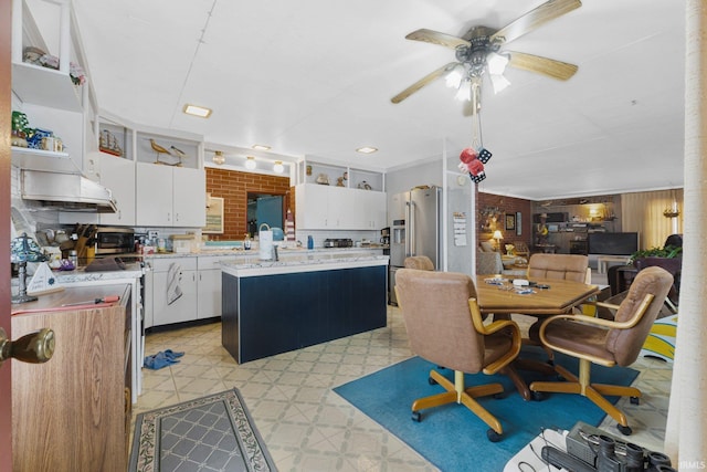 kitchen featuring ceiling fan, a kitchen island, white cabinetry, and stainless steel appliances