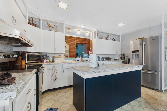 kitchen with white cabinets, stainless steel appliances, a kitchen island, and tasteful backsplash