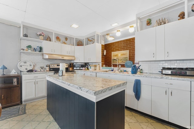 kitchen featuring a center island, white cabinets, sink, decorative backsplash, and appliances with stainless steel finishes