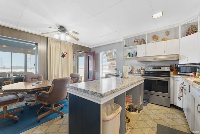 kitchen with appliances with stainless steel finishes, a kitchen island, ceiling fan, crown molding, and white cabinetry