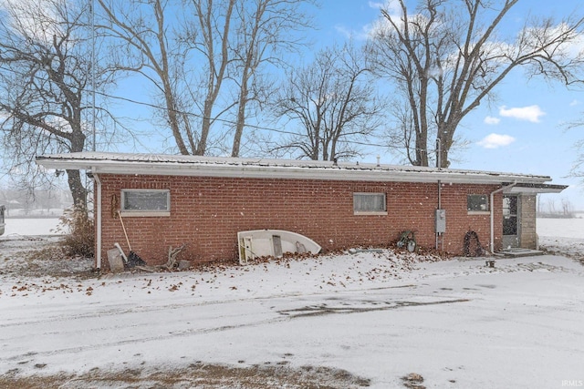 view of snow covered back of property