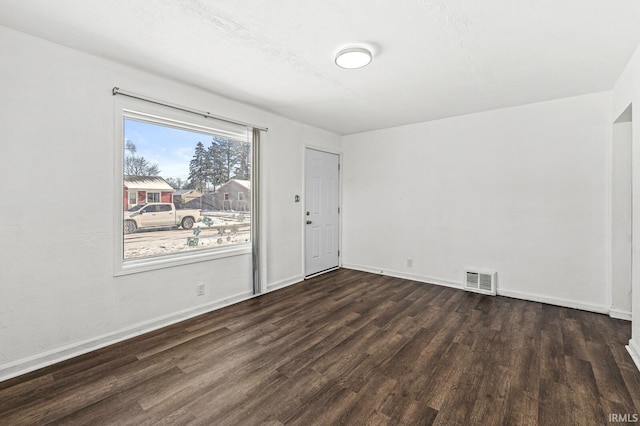 spare room with dark wood-type flooring