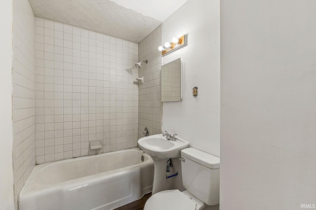 bathroom featuring toilet and tiled shower / bath