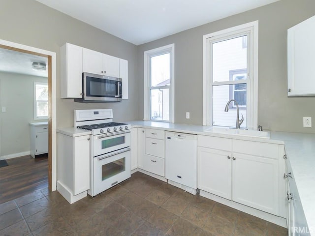 kitchen featuring sink, white appliances, and white cabinets