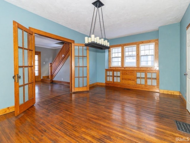 unfurnished dining area with french doors, ornamental molding, and dark hardwood / wood-style floors