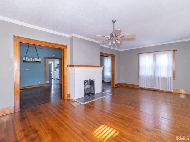 unfurnished living room with ceiling fan, dark wood-type flooring, a tile fireplace, and crown molding