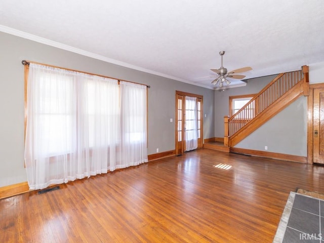 unfurnished living room featuring ceiling fan, dark wood-type flooring, and crown molding