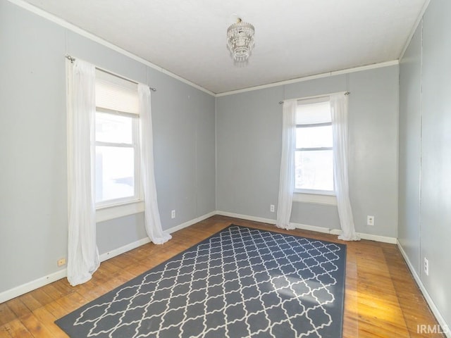 unfurnished room featuring wood-type flooring, ornamental molding, and a wealth of natural light