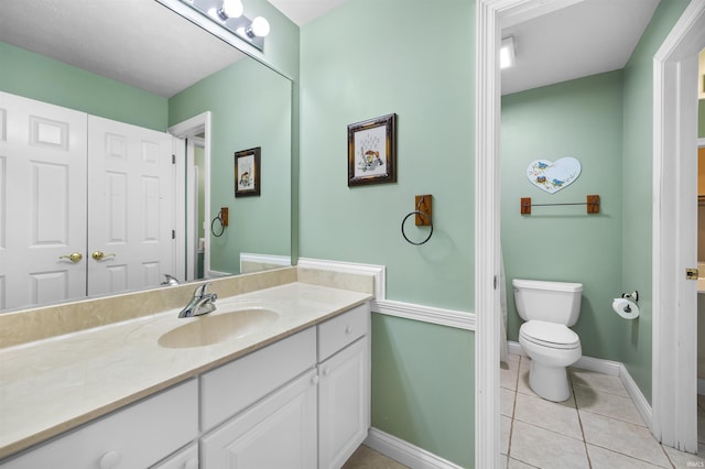 bathroom featuring toilet, tile patterned floors, and vanity