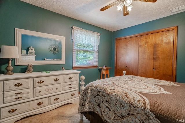 bedroom featuring a closet, carpet flooring, a textured ceiling, and ceiling fan