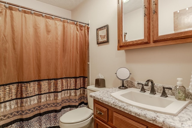 bathroom with toilet, vanity, and a textured ceiling