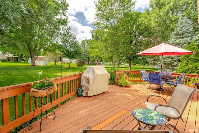 wooden terrace featuring a lawn and grilling area