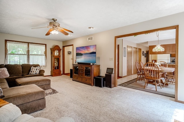 carpeted living room featuring a textured ceiling and ceiling fan