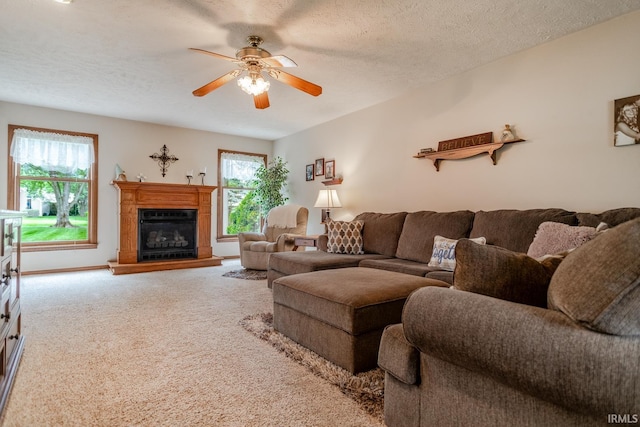 living room featuring carpet floors, ceiling fan, and a textured ceiling