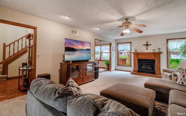 living room with a textured ceiling, ceiling fan, and parquet floors