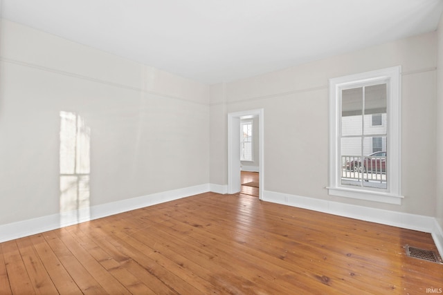 spare room with hardwood / wood-style floors and plenty of natural light