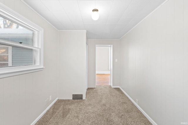 unfurnished room with crown molding and carpet