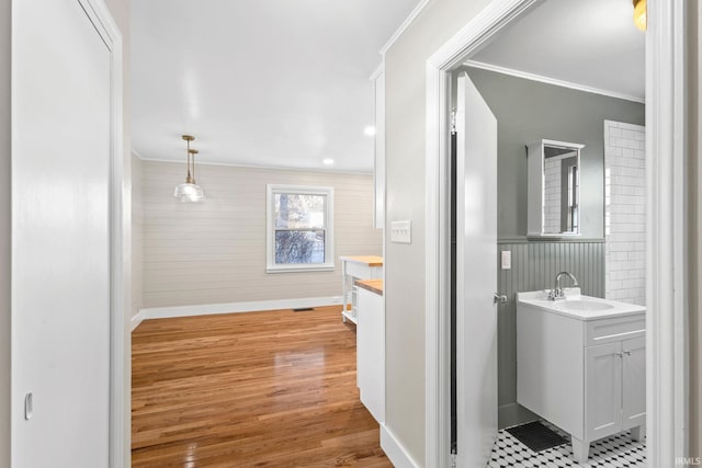 bathroom featuring vanity, hardwood / wood-style floors, and crown molding