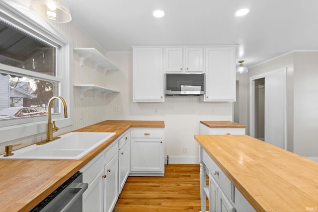 kitchen featuring wooden counters, white cabinets, appliances with stainless steel finishes, and sink