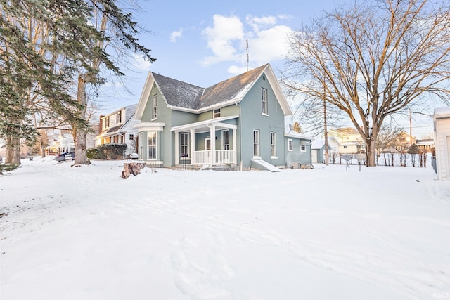 view of snow covered rear of property