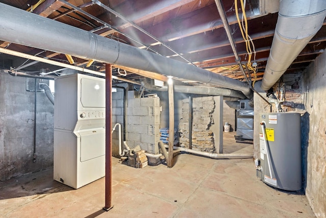 basement featuring stacked washer and clothes dryer and gas water heater