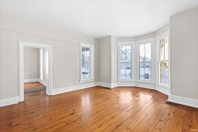 unfurnished room featuring hardwood / wood-style floors and a wealth of natural light