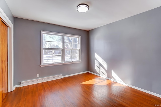 spare room featuring hardwood / wood-style flooring and baseboard heating