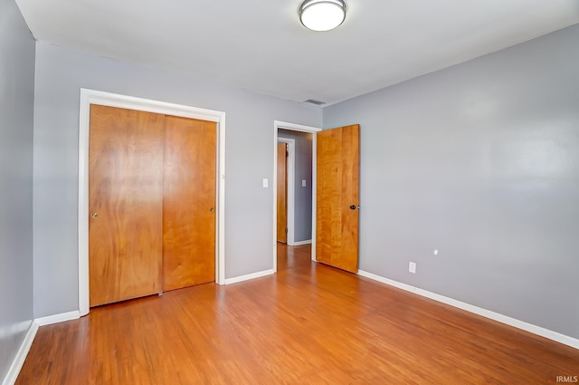 unfurnished bedroom featuring a closet and light wood-type flooring