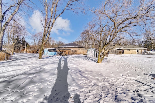 yard layered in snow with a storage unit