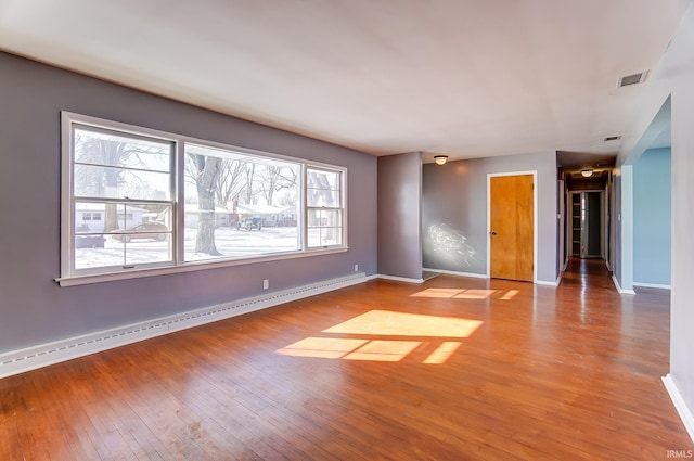 unfurnished room with a baseboard radiator, hardwood / wood-style floors, and plenty of natural light