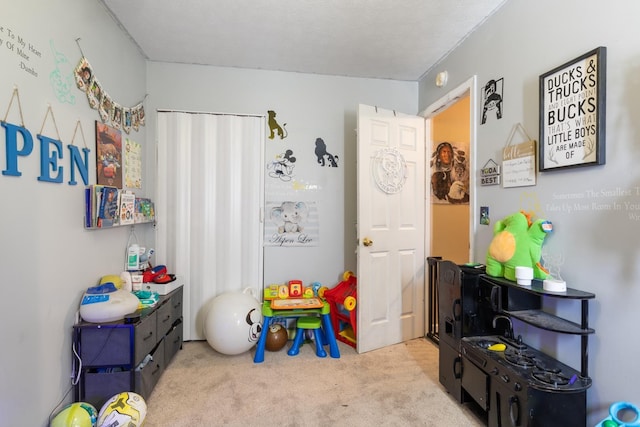 playroom featuring a textured ceiling and light carpet