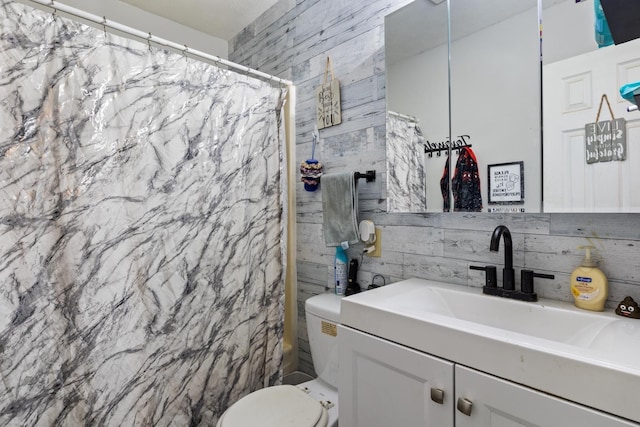 bathroom with toilet, vanity, and tile walls