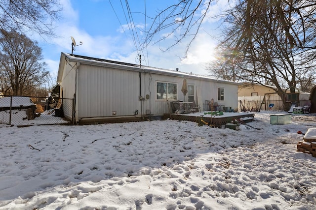 view of snow covered back of property