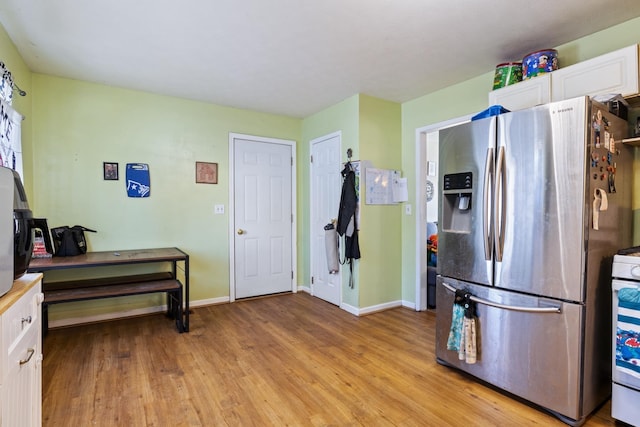 kitchen featuring light hardwood / wood-style flooring, stainless steel refrigerator with ice dispenser, and white cabinetry