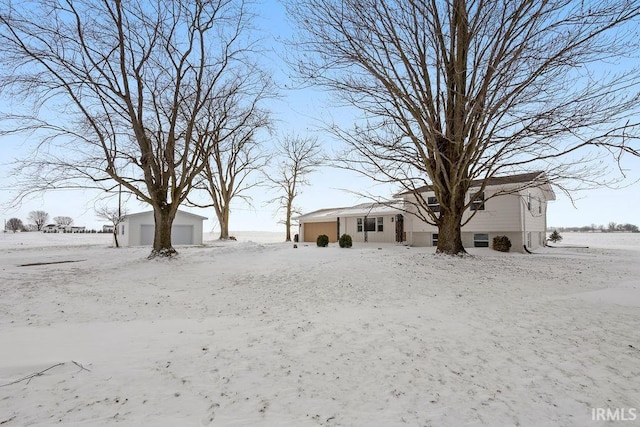 snowy yard with an outbuilding and a garage