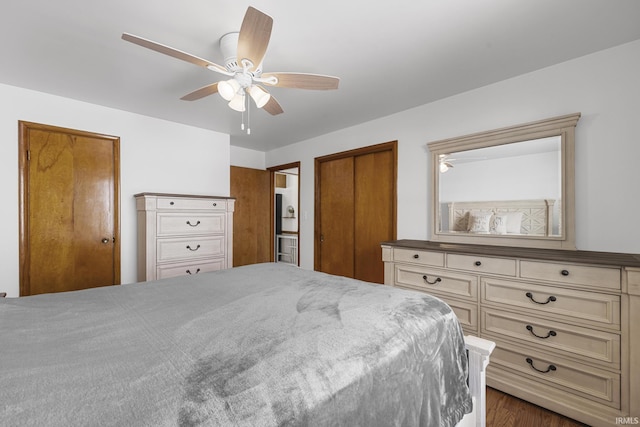 bedroom with ceiling fan and two closets