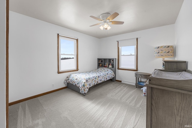 carpeted bedroom featuring multiple windows and ceiling fan