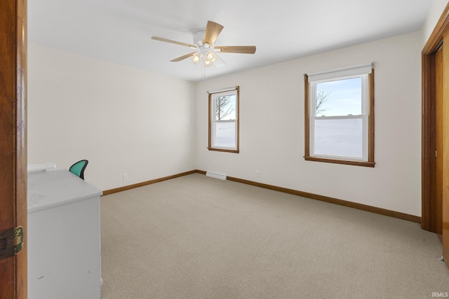 spare room featuring light colored carpet and ceiling fan