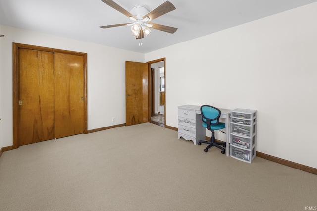 unfurnished office featuring ceiling fan and light colored carpet