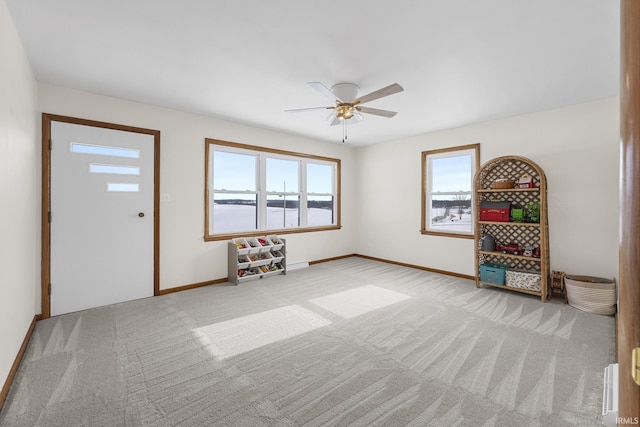 entrance foyer with ceiling fan and light colored carpet