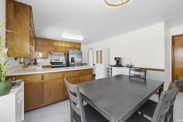 kitchen with stainless steel appliances, sink, kitchen peninsula, backsplash, and exhaust hood