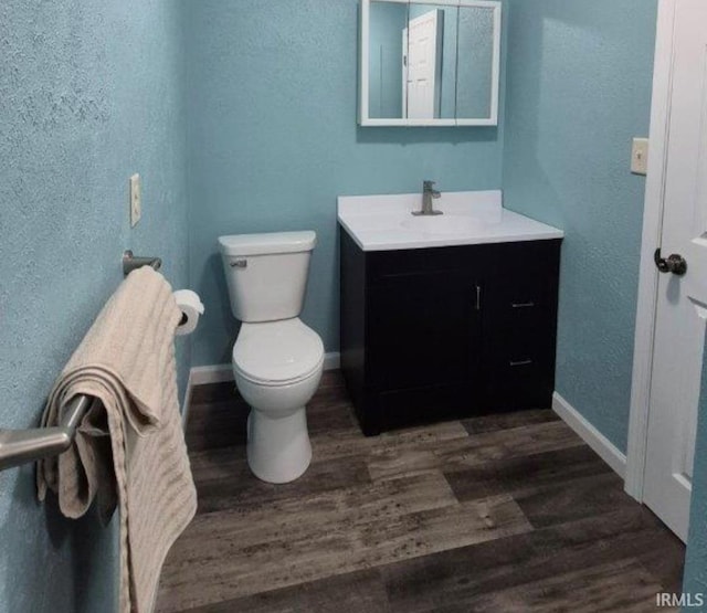 bathroom with hardwood / wood-style floors, vanity, and toilet