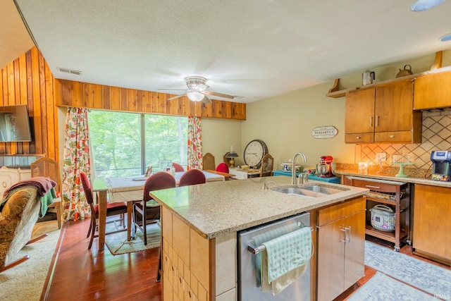 kitchen featuring sink, dishwasher, tasteful backsplash, dark hardwood / wood-style floors, and a center island with sink