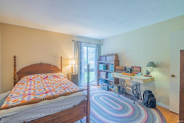 bedroom with a textured ceiling and light wood-type flooring