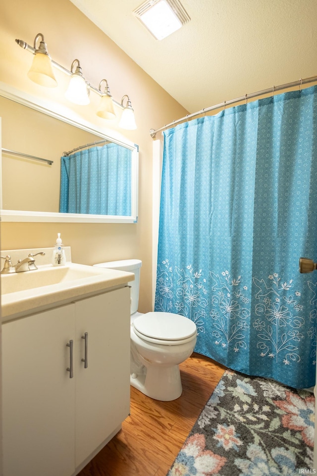 bathroom featuring toilet, a shower with shower curtain, wood-type flooring, and vanity