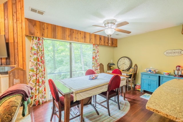 dining space featuring a textured ceiling, ceiling fan, and dark hardwood / wood-style flooring