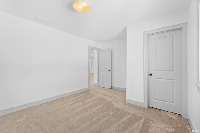 unfurnished bedroom featuring a closet and light carpet