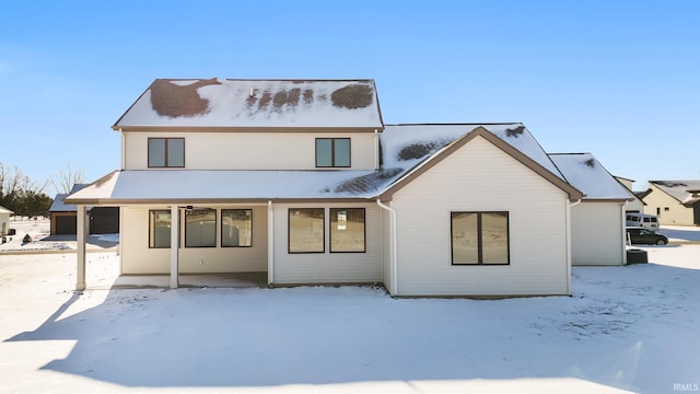 view of snow covered rear of property