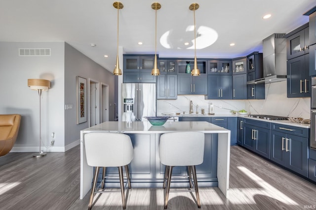 kitchen featuring appliances with stainless steel finishes, pendant lighting, blue cabinetry, and a center island